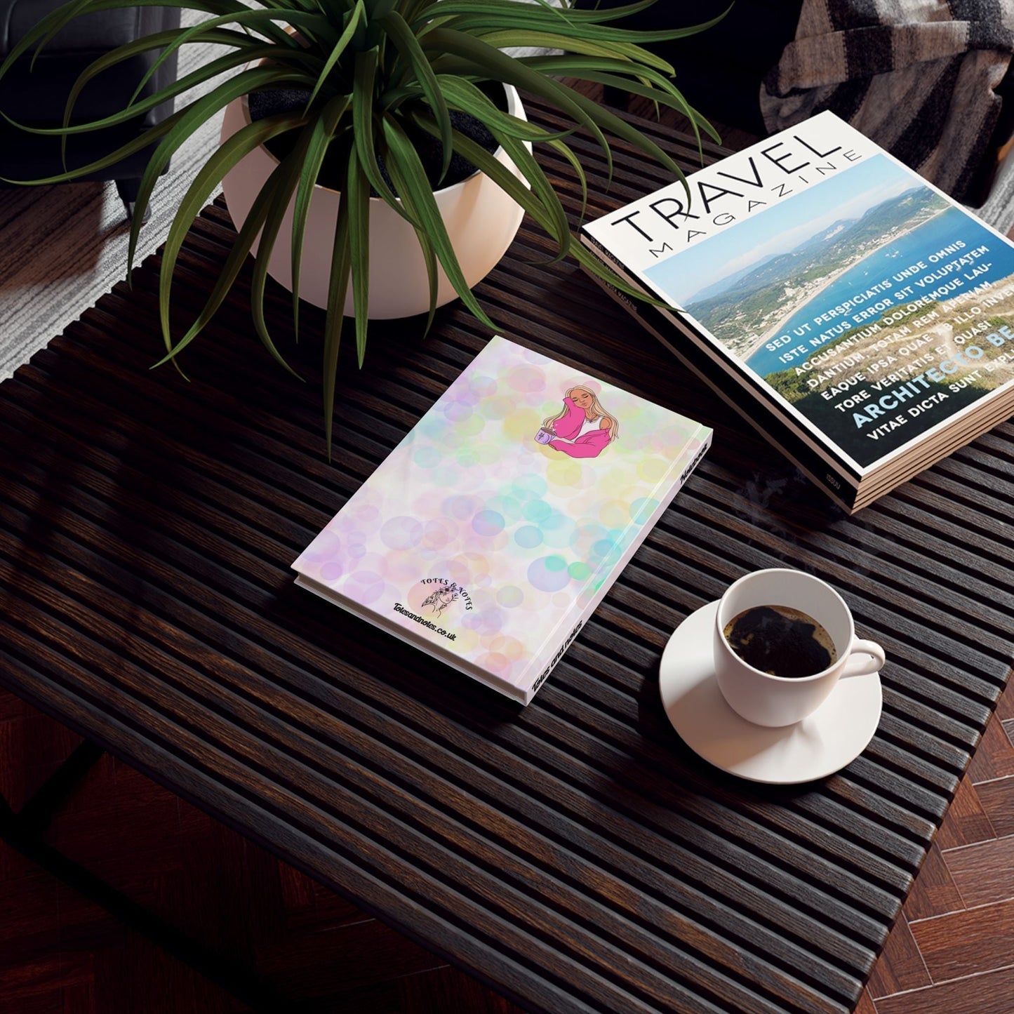 Vibrant hardcover notebook on a wooden table with a cup of coffee and travel magazine.