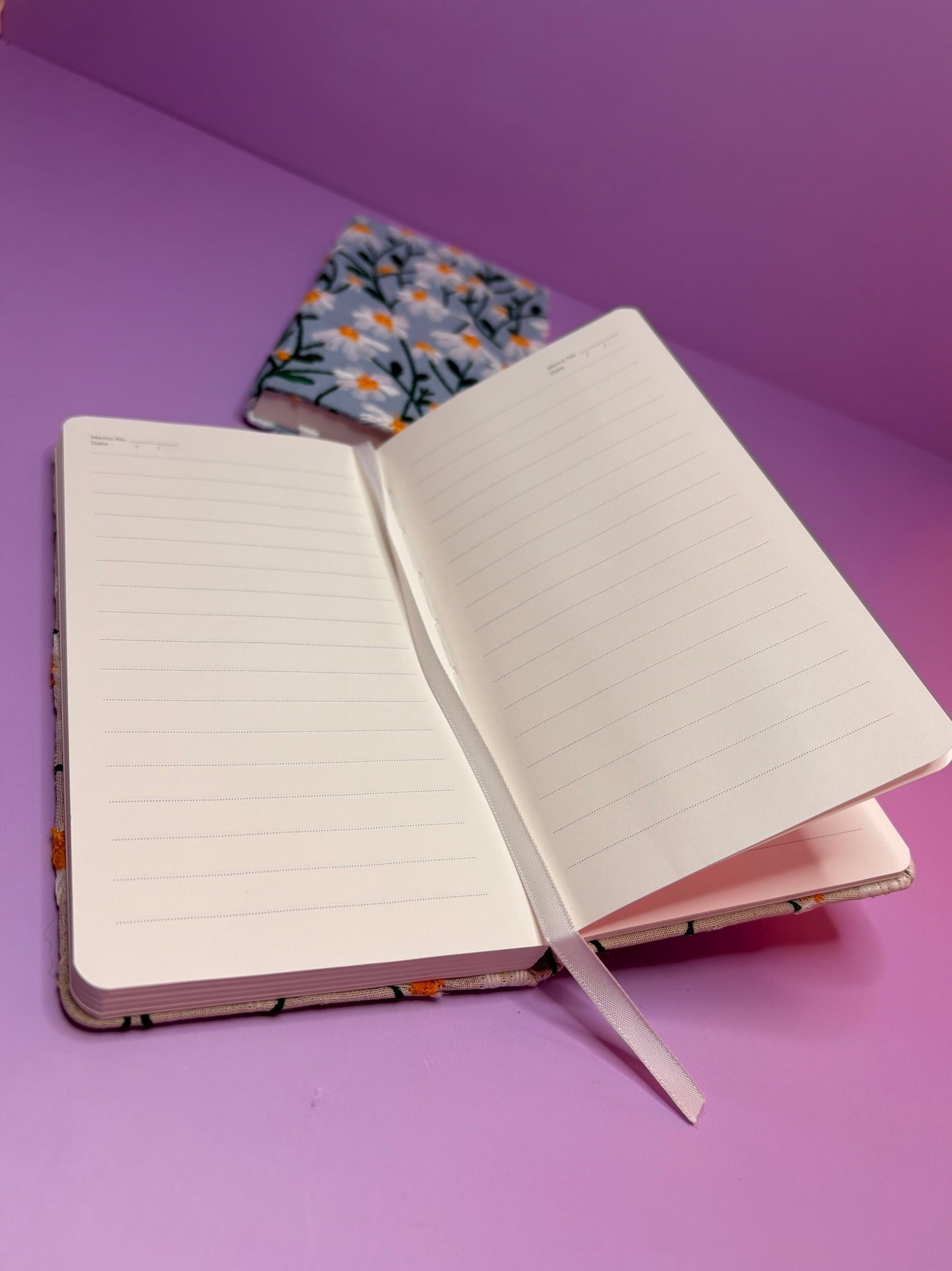 A6 Embroidered Daisy hardback notebook with lined pages and floral cover on purple background