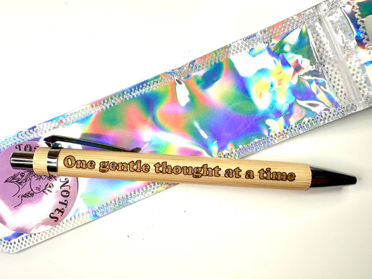 Engraved bamboo pen with "one gentle thought at a time" inscription, eco-friendly and refillable ballpoint pen with natural bamboo barrel.
