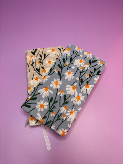 A6 embroidered daisy notebooks with hardback covers in blue and cream on purple background