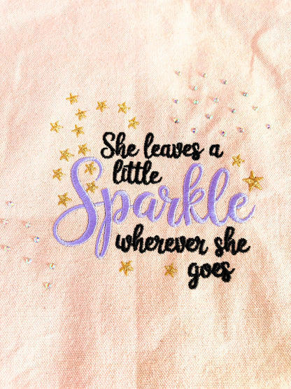 Embroidered canvas tote bag with "She Leaves a Little Sparkle Wherever She Goes" slogan and sparkling diamante embellishments
