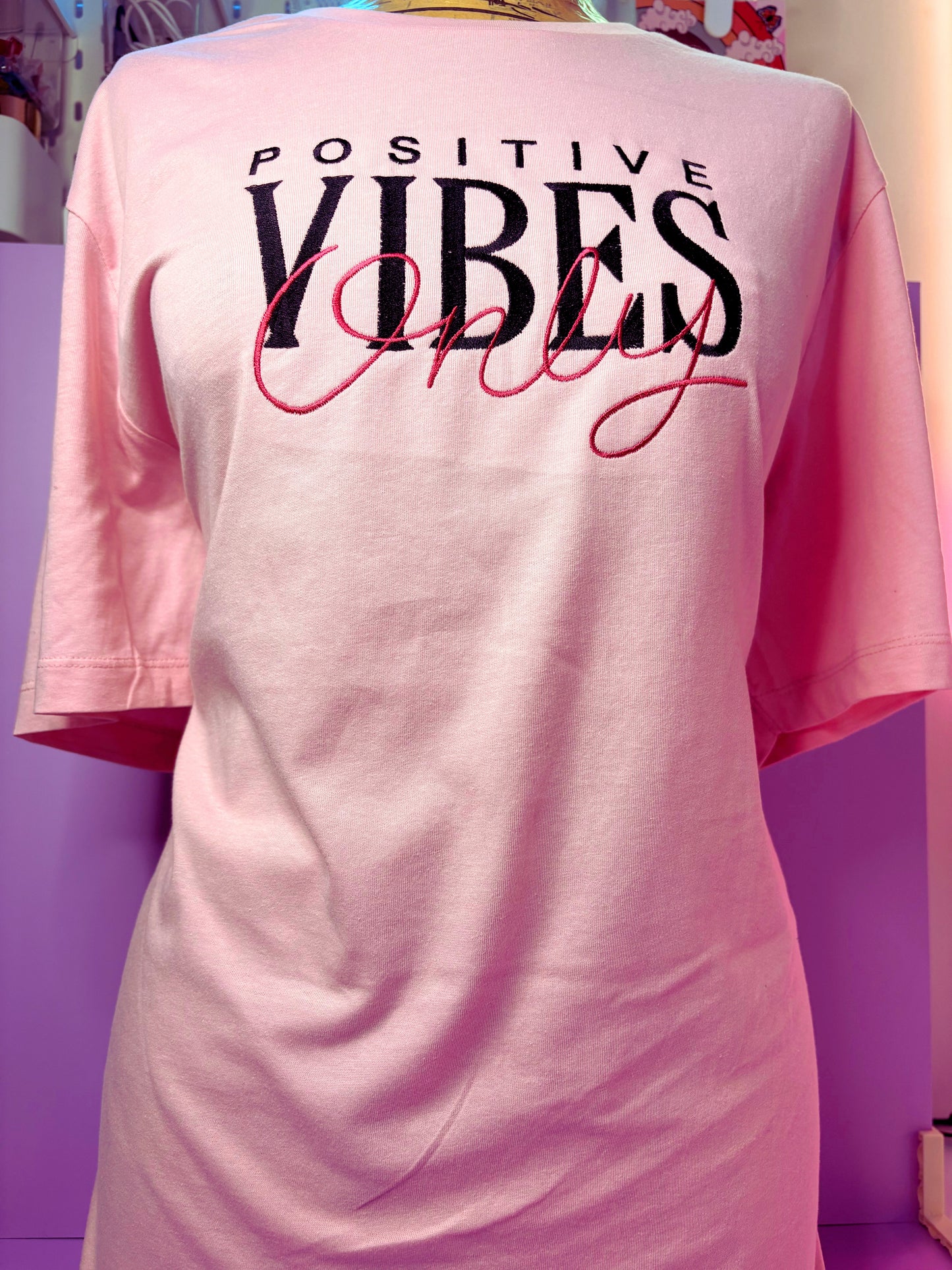 Baby pink short sleeve t-shirt with embroidered "Positive Vibes Only" text and ribbed crew neck