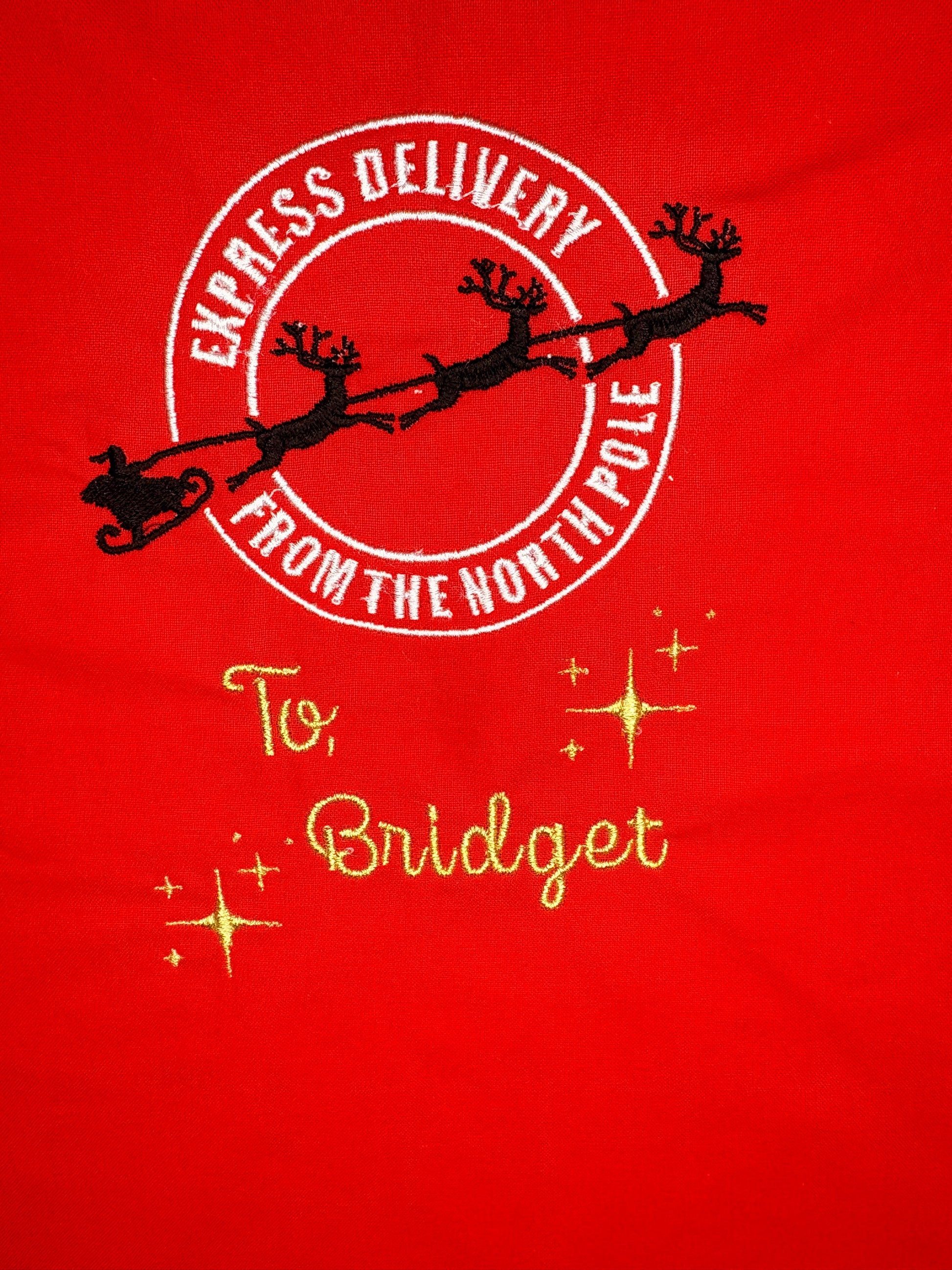 Red personalised Christmas sack with gold embroidered "Special Delivery from the North Pole" and name "Bridget"