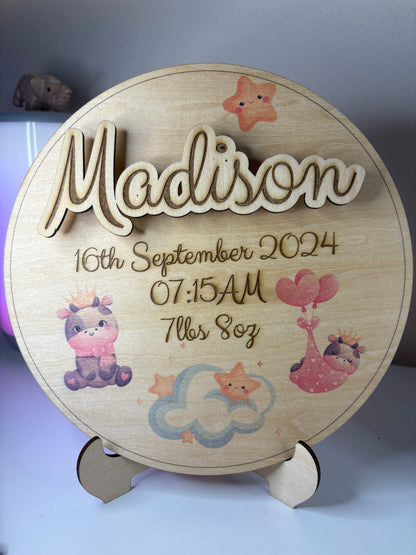 Personalised baby birth announcement plaque in basswood with 3D name, birth details, and cute illustrations on a round stand