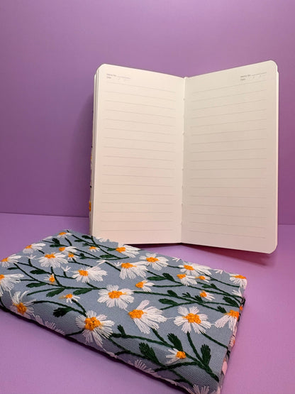 A6 embroidered daisy notebook with hardback floral cover and lined pages in blue or cream colors