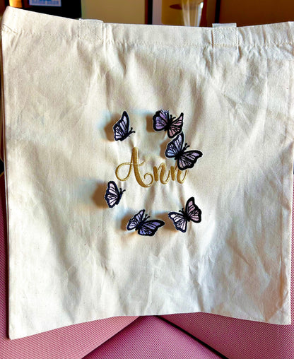 Embroidery butterfly tote bag with personalized gold name on cotton fabric.