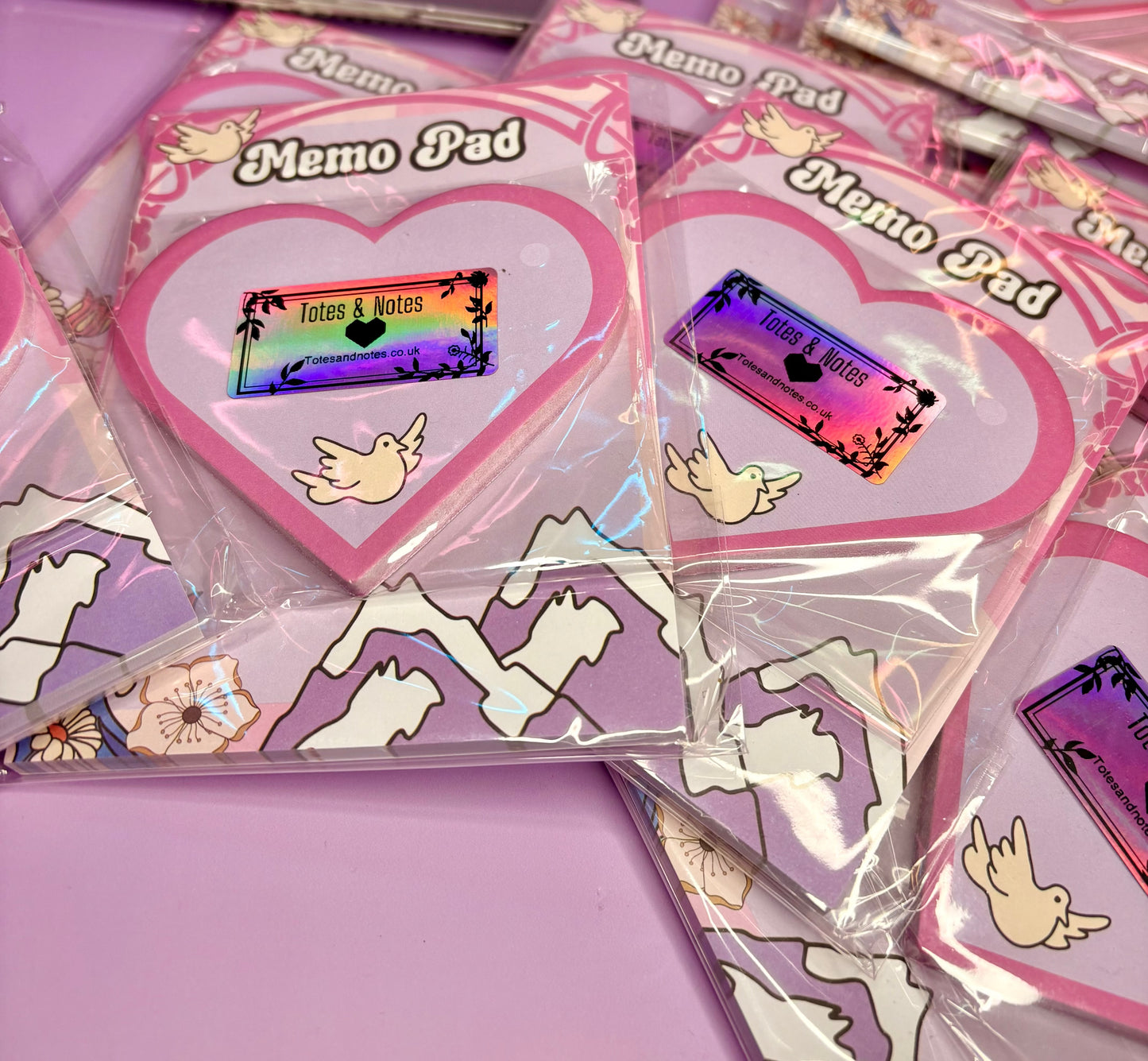 Breathe & Bloom heart-shaped sticky notes with pastel pink color and dove motif in packaging on purple background