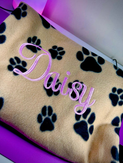 personalised dog blanket with paw print design and embroidered name on soft fleece