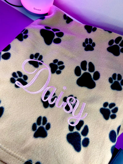 Personalised dog blanket with paw prints and embroidered name, soft fleece.