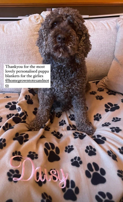 Personalised dog blanket with paw prints and embroidered name for cosy comfort.