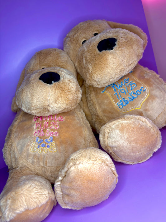 Two personalised birth announcement soft toy dogs with embroidered birth details on soft plush fabric