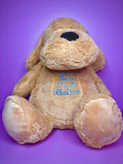 Personalised birth announcement soft toy dog with embroidered baby details on purple background