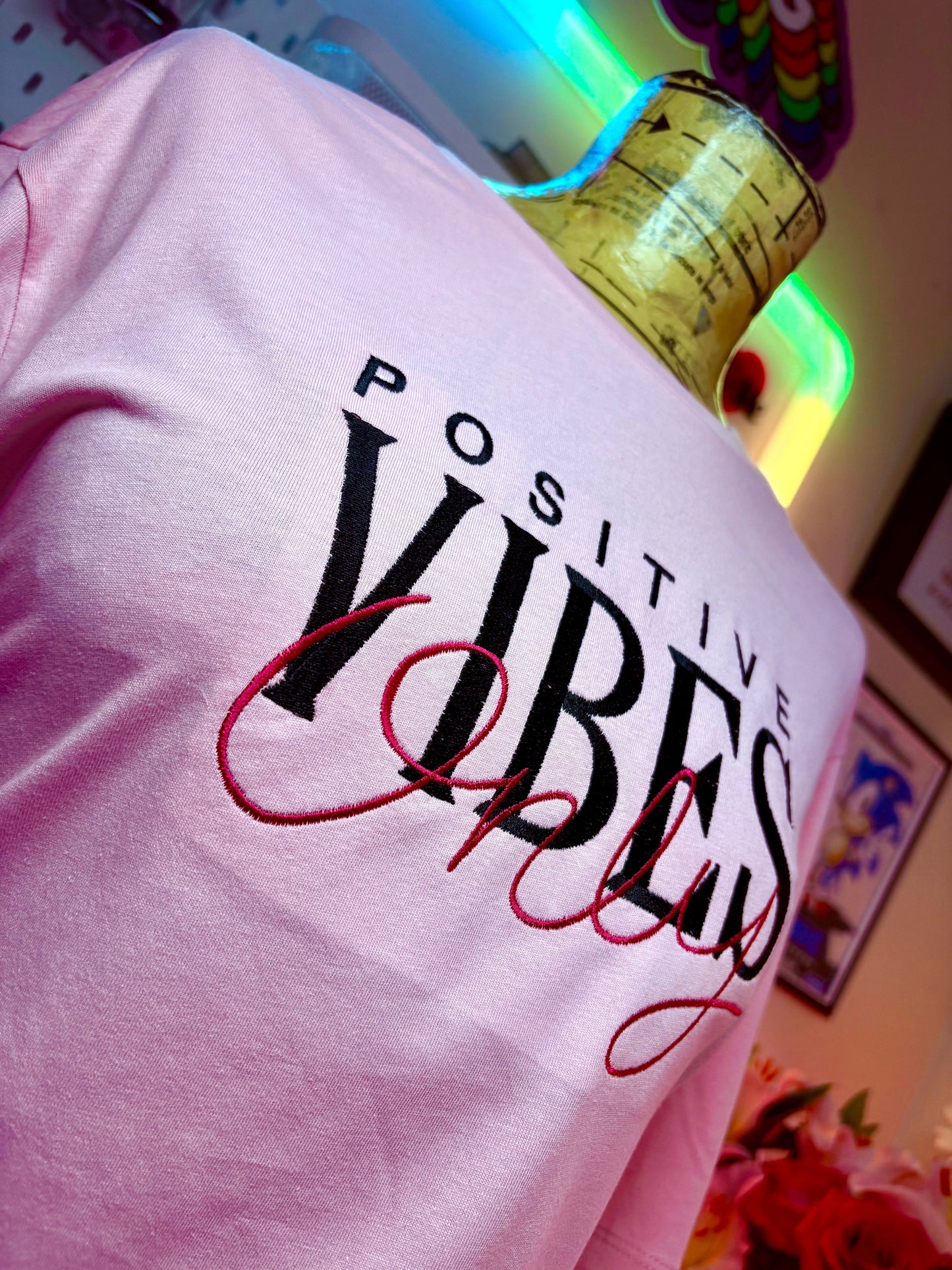 Baby pink short sleeve t-shirt with embroidered Positive Vibes Only text and ribbed crew neck