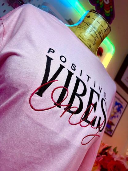 Baby pink short sleeve t-shirt with embroidered Positive Vibes Only text and ribbed crew neck