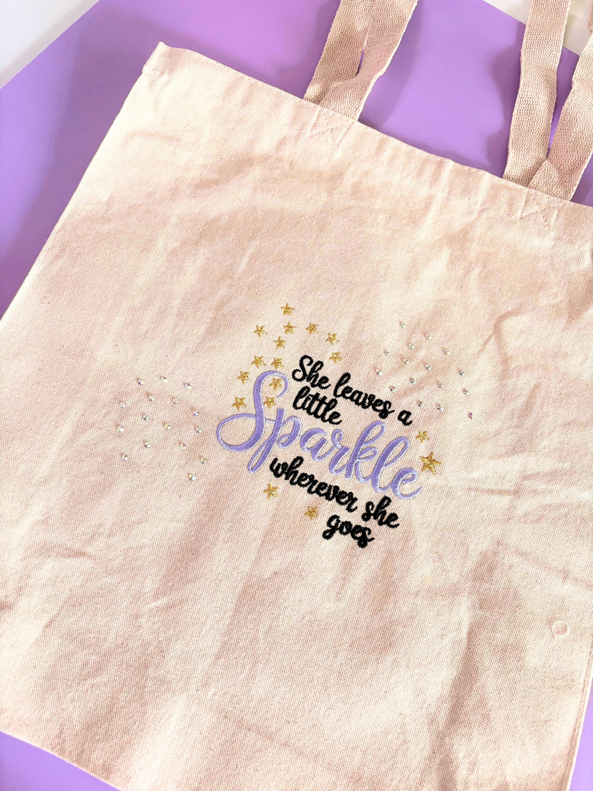 Canvas tote bag embroidered with "She Leaves a Little Sparkle Wherever She Goes" slogan and sparkling diamante embellishments