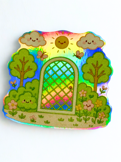 Holographic kawaii sticker featuring a smiling sun, clouds, trees, flowers, and a garden gate with rainbow shimmer effect.
