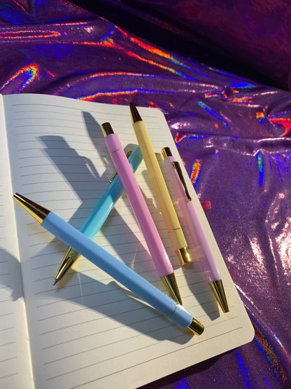 Pastel paradise pen set with gold trim on open notebook, blue ink stationery, 5 pcs.