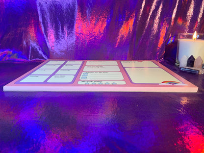 The Pretty in Pink A4 Desk Planner with colorful layout on reflective surface.