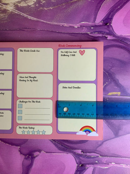 The Pretty in Pink A4 Desk Planner with colorful design and writing sections.